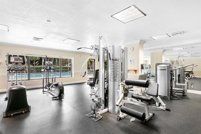 workout area featuring visible vents, a textured ceiling, and baseboards