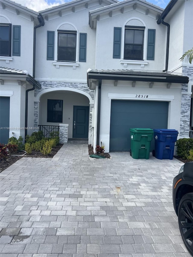28518 SW 134th Ave, Homestead, FL 33033 - view of front of home featuring decorative driveway, a garage, stone siding, and stucco siding