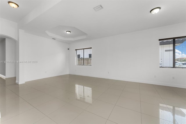 14555 SW 32nd St, Miami, FL 33175 - spare room featuring baseboards, tile patterned flooring, visible vents, a tray ceiling, and arched walkways