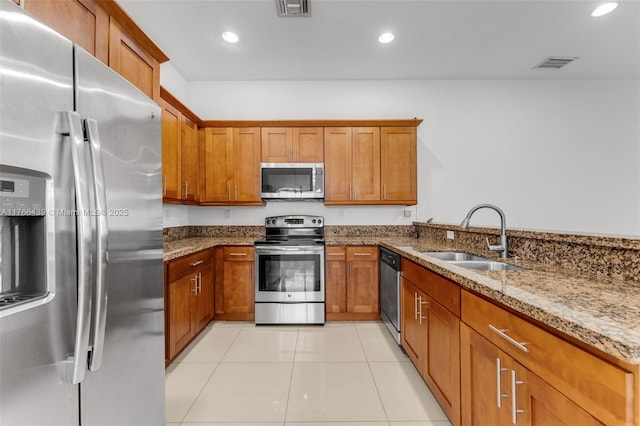 14555 SW 32nd St, Miami, FL 33175 - kitchen with stainless steel appliances, stone countertops, brown cabinetry, and a sink