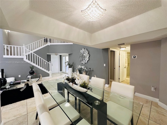 dining area featuring a notable chandelier, a textured ceiling, stairway, light tile patterned flooring, and baseboards