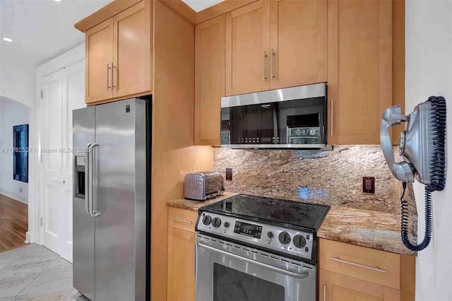 kitchen with light stone countertops, a sink, dishwasher, decorative light fixtures, and tasteful backsplash
