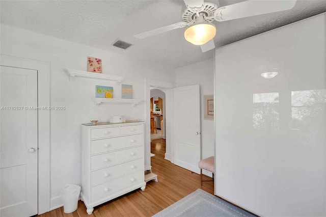 bedroom featuring multiple windows, wood finished floors, and a ceiling fan