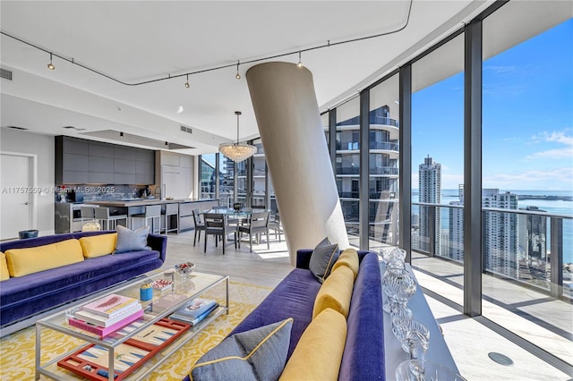 living area featuring a city view, visible vents, light wood-style floors, and expansive windows