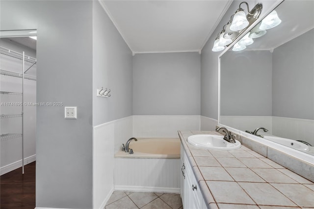 bathroom featuring ornamental molding, tile patterned floors, vanity, and a garden tub