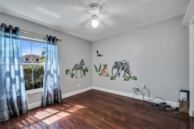 spare room with a textured ceiling, wood finished floors, and a ceiling fan