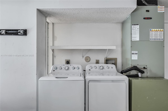 laundry room with washer and dryer, a textured ceiling, and heating unit
