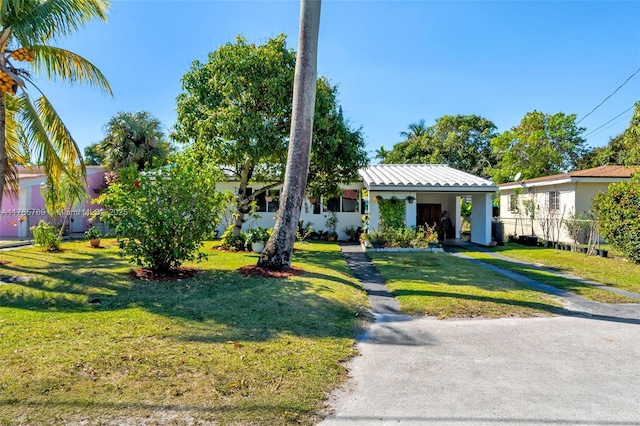 ranch-style house featuring a front yard and an attached carport