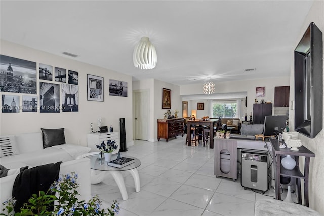 living area featuring a chandelier, marble finish floor, and visible vents