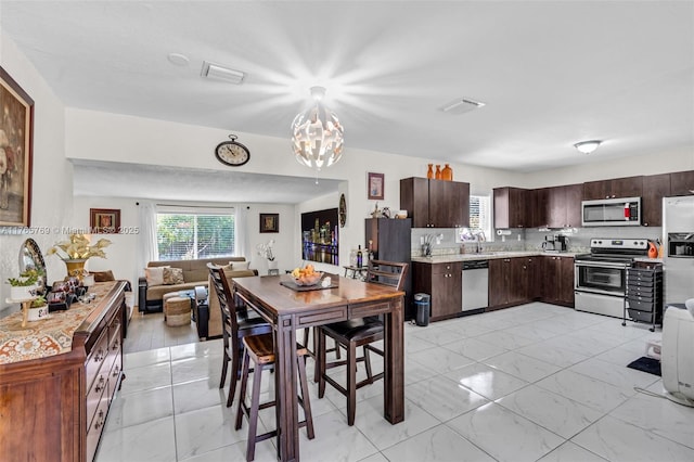 dining area with marble finish floor, a notable chandelier, and visible vents