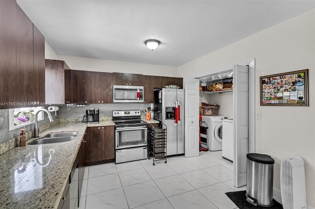 kitchen with a sink, stainless steel appliances, marble finish floor, light stone counters, and dark brown cabinets