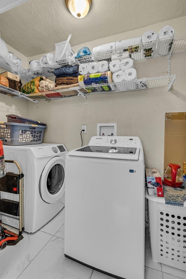 laundry area with laundry area, marble finish floor, and washer and dryer