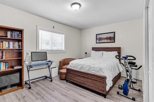 bedroom featuring baseboards and wood finished floors