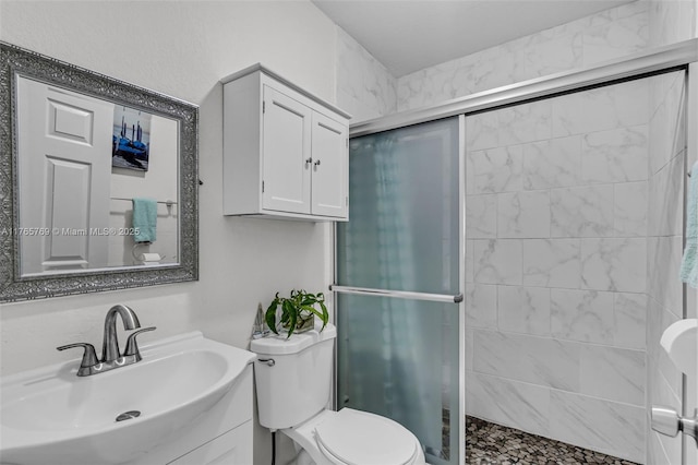 bathroom with vanity, toilet, and a stall shower