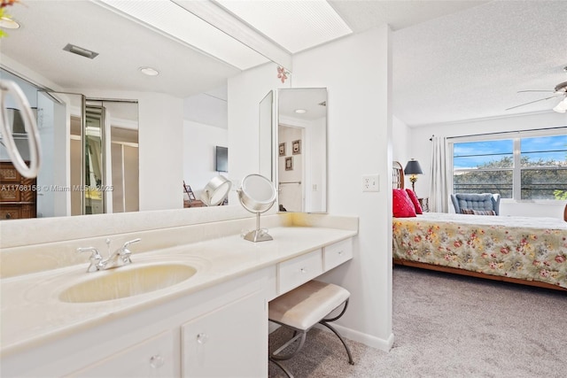 12950 SW 4th Ct Unit 309H, Pembroke Pines, FL 33027 - ensuite bathroom featuring a textured ceiling, connected bathroom, baseboards, ceiling fan, and vanity