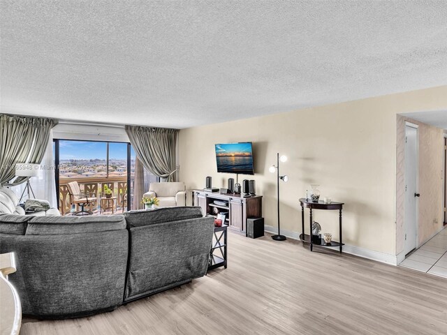 800 NE 195th St Unit 716, Miami, FL 33179 - living area featuring baseboards, a textured ceiling, and light wood-style floors