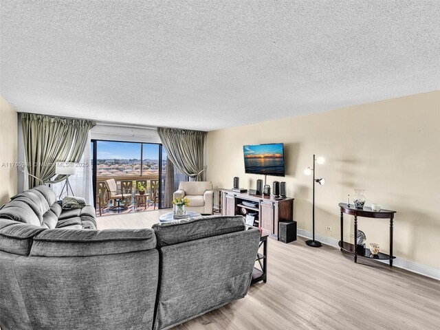 800 NE 195th St Unit 716, Miami, FL 33179 - living area with light wood-type flooring, baseboards, and a textured ceiling