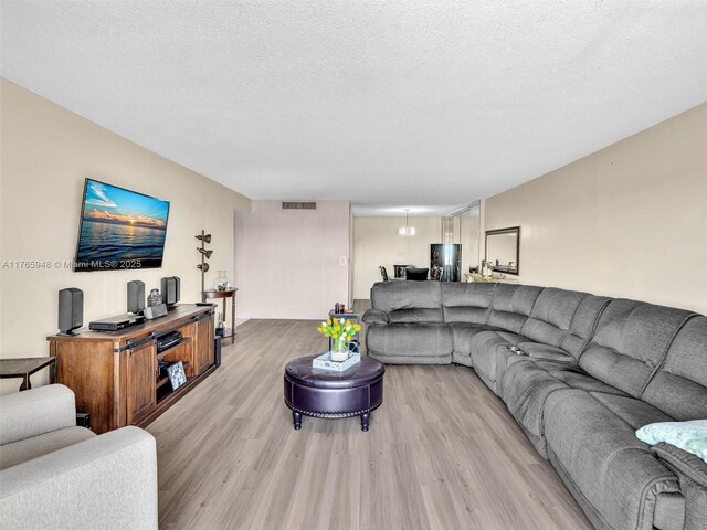 800 NE 195th St Unit 716, Miami, FL 33179 - living area with light wood-style flooring, visible vents, and a textured ceiling
