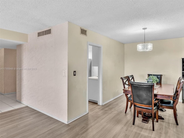 800 NE 195th St Unit 716, Miami, FL 33179 - dining space with visible vents, a textured ceiling, and wood finished floors