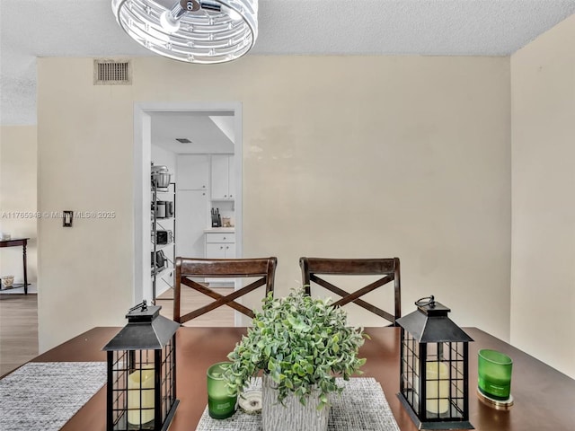 800 NE 195th St Unit 716, Miami, FL 33179 - dining room featuring visible vents, a textured ceiling, and wood finished floors