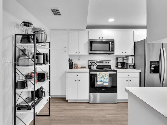 800 NE 195th St Unit 716, Miami, FL 33179 - kitchen featuring light wood finished floors, visible vents, stainless steel appliances, and light countertops