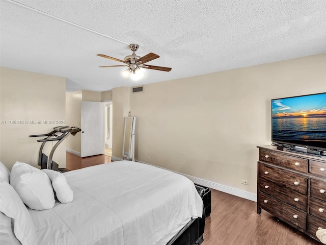 800 NE 195th St Unit 716, Miami, FL 33179 - bedroom with a ceiling fan, baseboards, wood finished floors, visible vents, and a textured ceiling