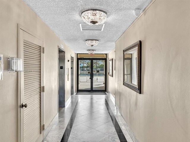 800 NE 195th St Unit 716, Miami, FL 33179 - hall with elevator, baseboards, and a textured ceiling