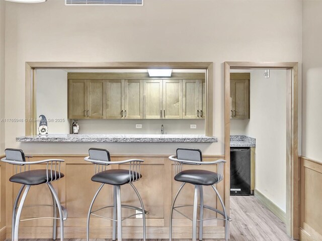 800 NE 195th St Unit 716, Miami, FL 33179 - kitchen featuring a kitchen breakfast bar, visible vents, and light wood finished floors