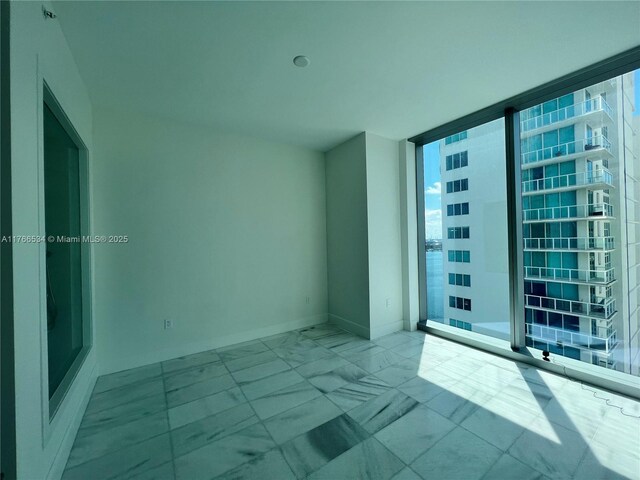700 NE 26th Ter Unit 2205, Miami, FL 33137 - spare room featuring baseboards and marble finish floor