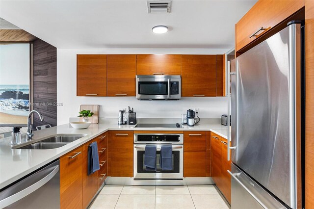 kitchen with visible vents, modern cabinets, a sink, stainless steel appliances, and light countertops