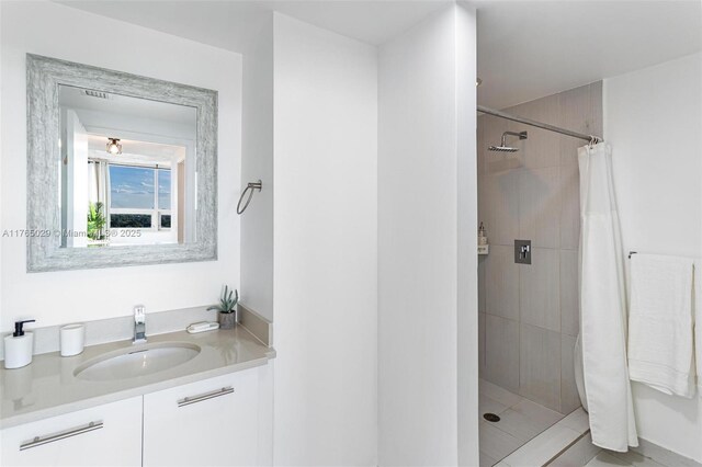 bathroom featuring vanity and tiled shower