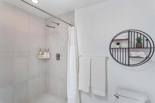 bathroom featuring toilet and a tile shower