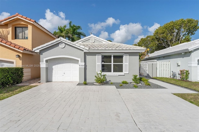 view of front of home featuring decorative driveway, a garage, and stucco siding