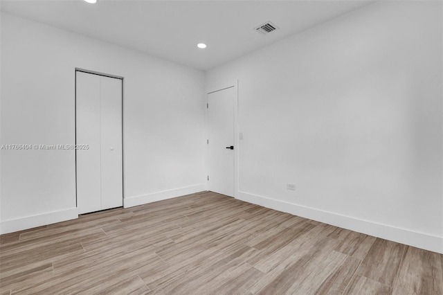 unfurnished room featuring recessed lighting, visible vents, baseboards, and light wood-style floors