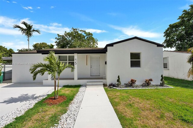 view of front of home featuring stucco siding, concrete driveway, and a front yard