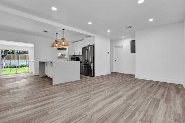 kitchen with open floor plan, white cabinets, visible vents, and appliances with stainless steel finishes