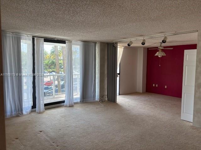 3701 N Country Club Dr Unit 207, Aventura, FL 33180 - carpeted empty room with a textured ceiling, a wall of windows, and track lighting