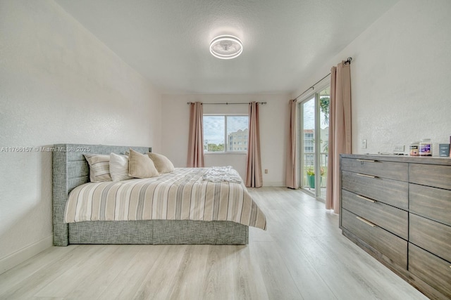 bedroom with light wood finished floors and baseboards