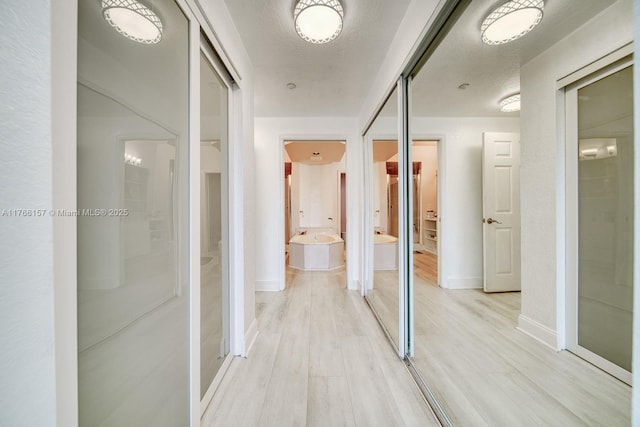 hallway with baseboards and light wood finished floors