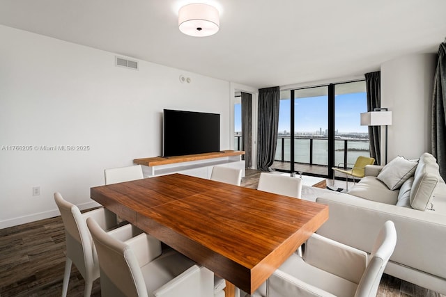 dining area with visible vents, floor to ceiling windows, baseboards, and wood finished floors
