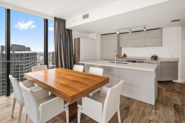 dining space with floor to ceiling windows, visible vents, and light wood-type flooring