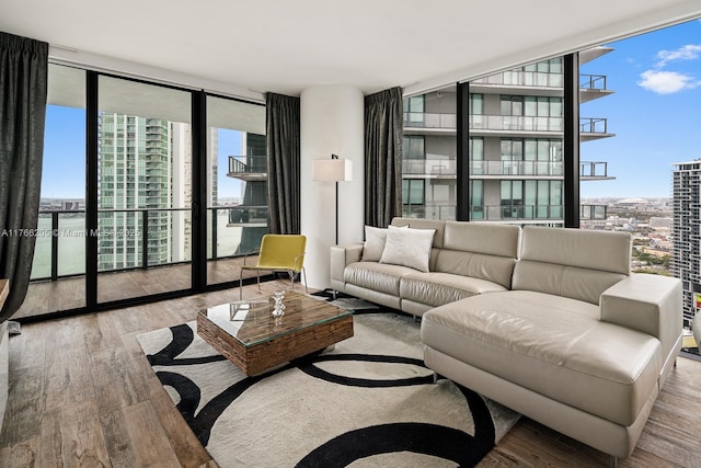 living area with a wall of windows, plenty of natural light, and wood finished floors