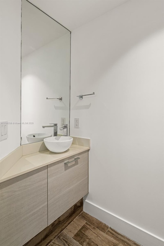bathroom with vanity, baseboards, and wood finished floors