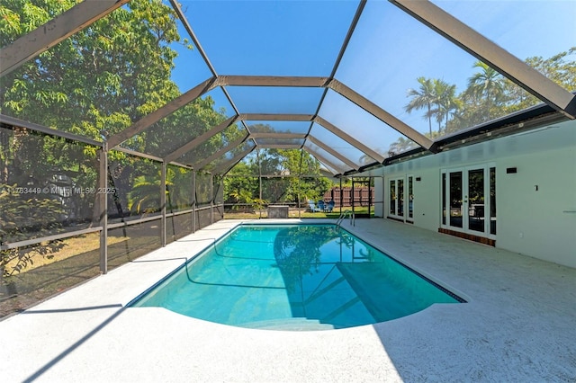 outdoor pool with a lanai, french doors, and a patio area