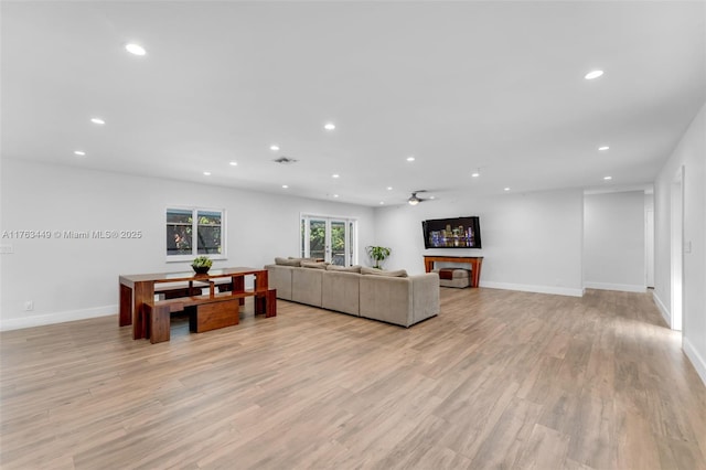 living room featuring visible vents, baseboards, ceiling fan, recessed lighting, and light wood-style flooring