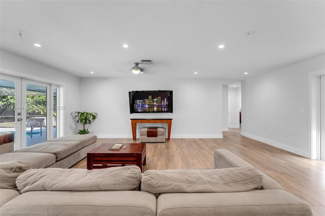 living room with recessed lighting, light wood-style flooring, and baseboards