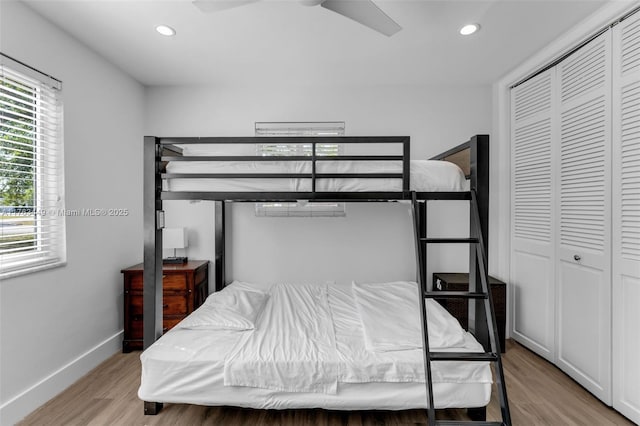 bedroom featuring a closet, a ceiling fan, recessed lighting, light wood finished floors, and baseboards