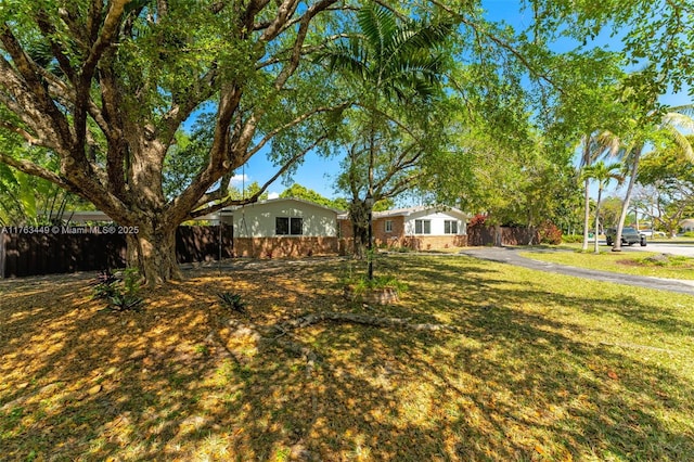 view of front facade featuring a front yard and fence
