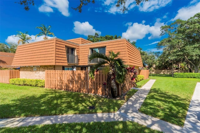 view of side of property with a lawn and fence