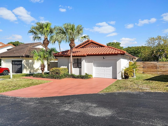 13481 SW 103rd St, Miami, FL 33186 - mediterranean / spanish-style house with stucco siding, fence, a garage, a tile roof, and a front yard